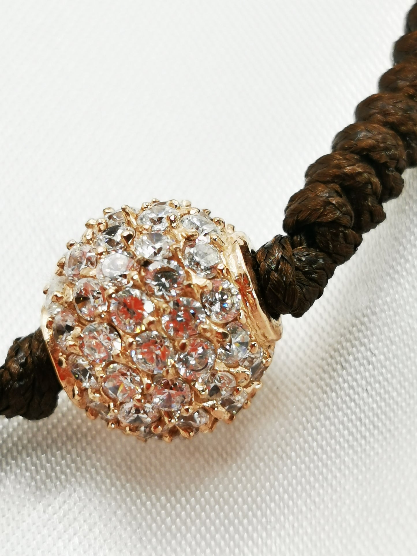 Pulsera de hilo con bola oro rosa de circonitas blancas